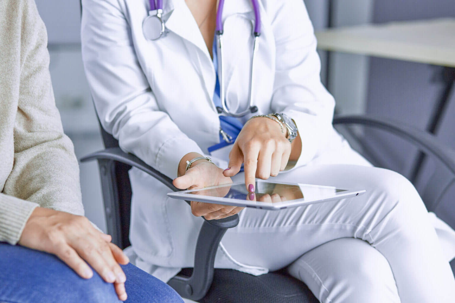 female doctor talking to a patient on a tablet.