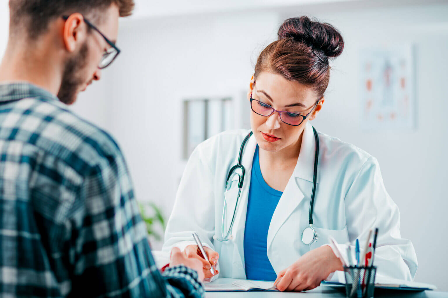 Woman Doctor prescribes medicine to young patient to treating his disease